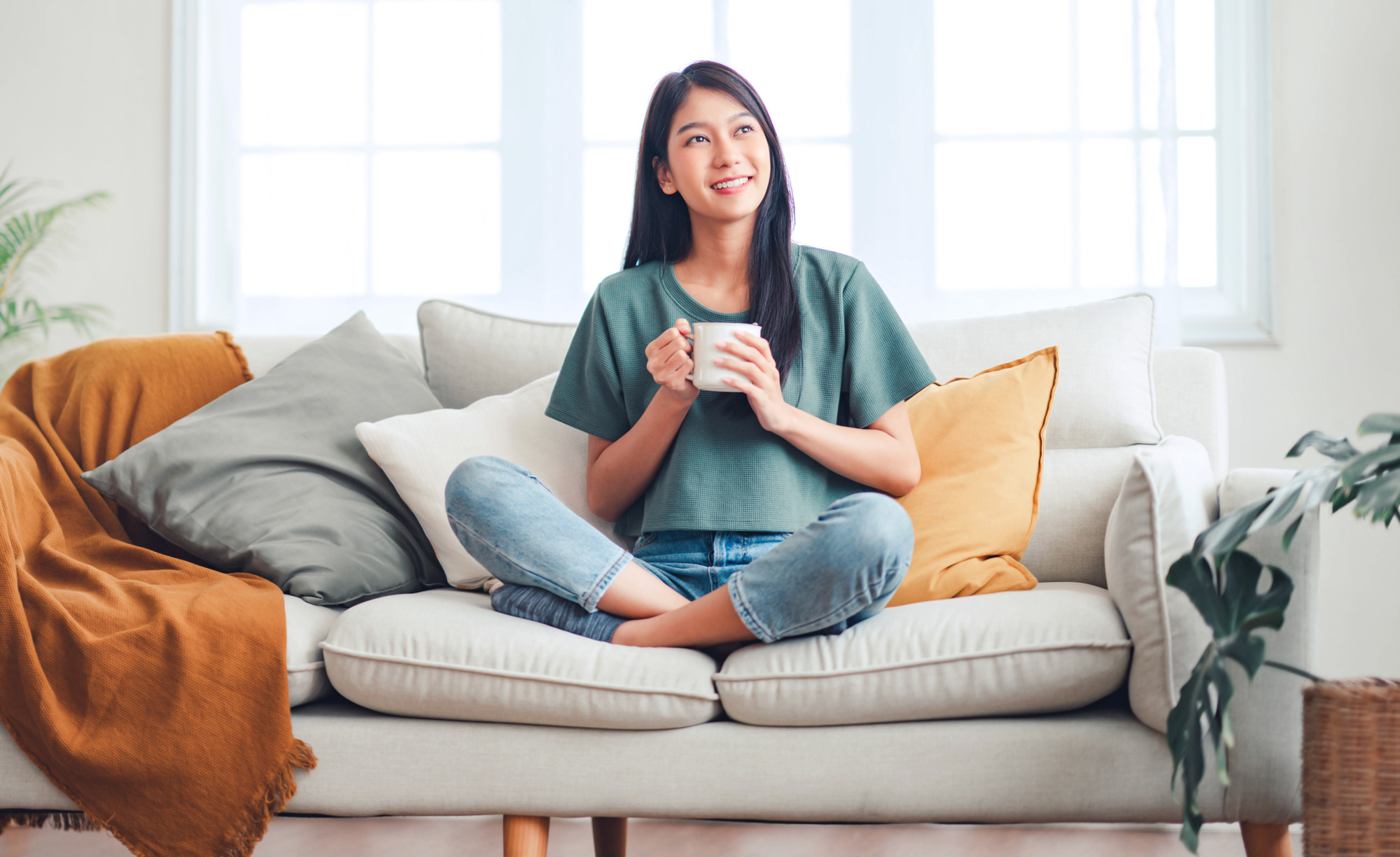 Girl on couch enjoying a cup of coffee